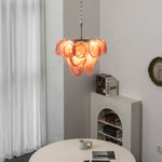 Vaucelle Swirled Glass Disc Tiered Chandelier | Swirled Glass and Brass | Hanging in a modern room near a decorative fireplace ledge | Severn Lighting