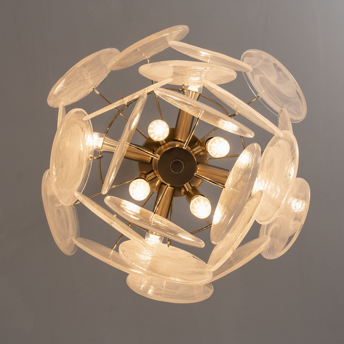 Vaucelle Swirled Glass Disc Tiered Chandelier | Swirled Glass and Brass | Bottom-up view of white glass disc variant showing internal frame and bulbs | Severn Lighting