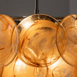 Vaucelle Swirled Glass Disc Tiered Chandelier | Swirled Glass and Brass | Close-up shot of yellow amber swirled glass discs on brass hooks | Severn Lighting