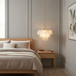 Vaucelle Swirled Glass Disc Tiered Chandelier | Swirled Glass and Brass | Styled in a luxury bedroom suite with neutral decor and bed | Severn Lighting