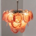 Vaucelle Swirled Glass Disc Tiered Chandelier | Swirled Glass and Brass | Reddish-orange swirled glass variant illuminated on neutral backdrop | Severn Lighting