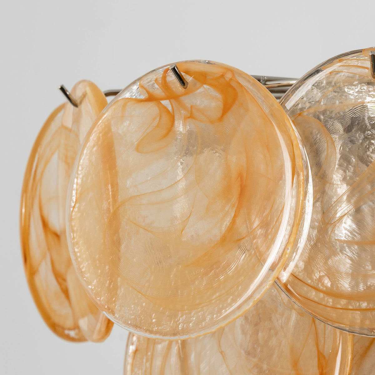 Vaucelle Swirled Glass Disc Tiered Chandelier | Swirled Glass and Brass | Reddish-orange swirled glass variant illuminated on neutral backdrop | Severn Lighting