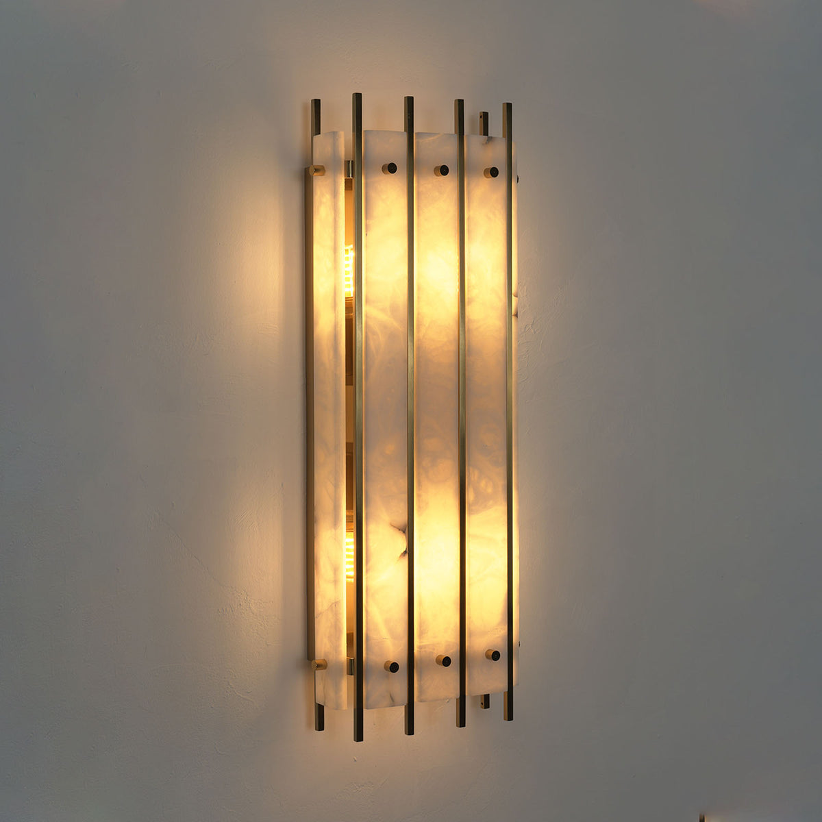 Veraune Bar Wall Sconce | Alabaster and Brass | Front illuminated view on dark wall with warm backlight | Severn Lighting