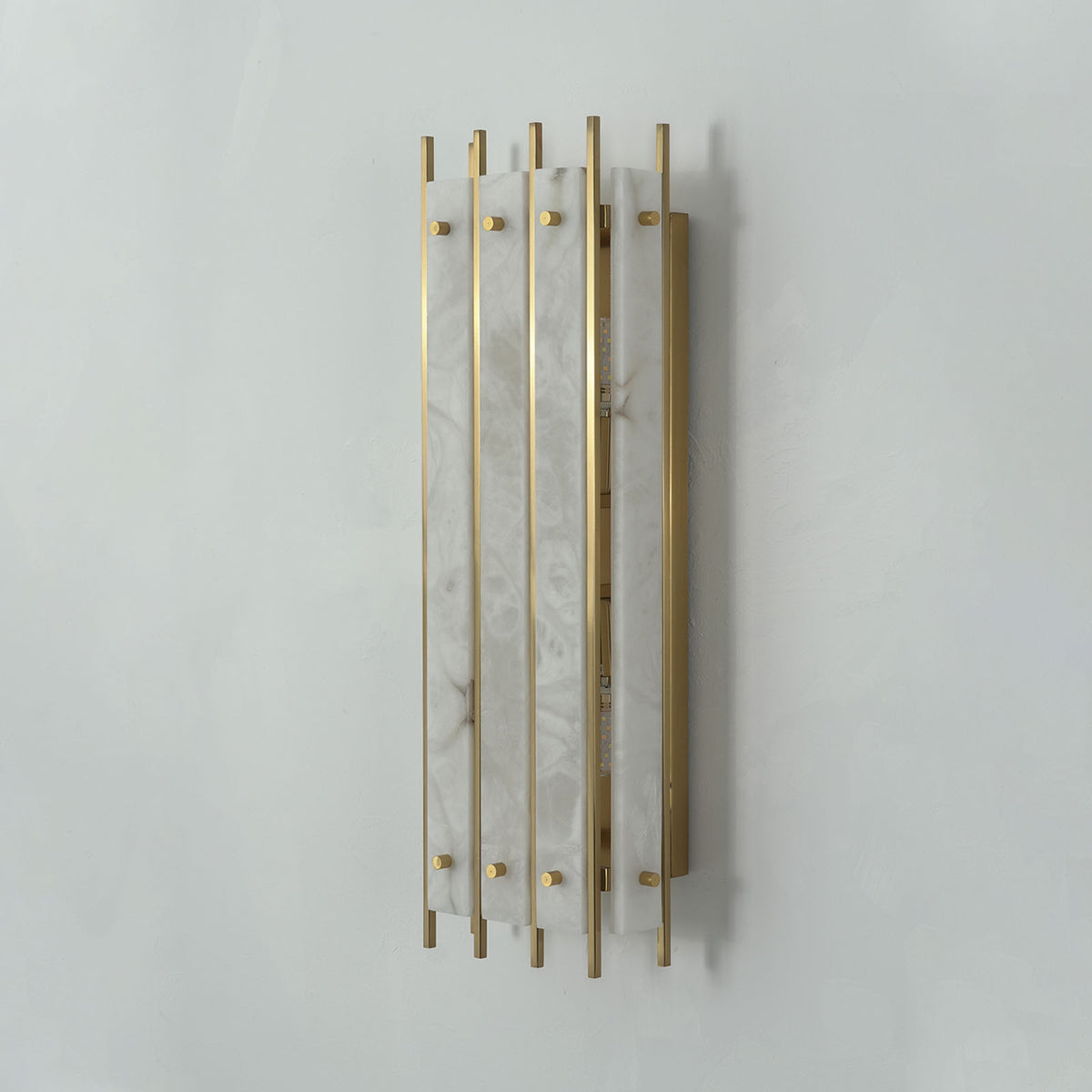 Veraune Bar Wall Sconce | Natural Stone and Brass | Angled three-quarter perspective on grey wall, unlit | Severn Lighting