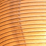 Verena Ribbed Paper Column Floor Lamp | Ribbed Paper and Metal Tripod Legs | Extreme close-up shot detailing the horizontal ribbed texture of the warm glowing paper lantern | Severn Lighting