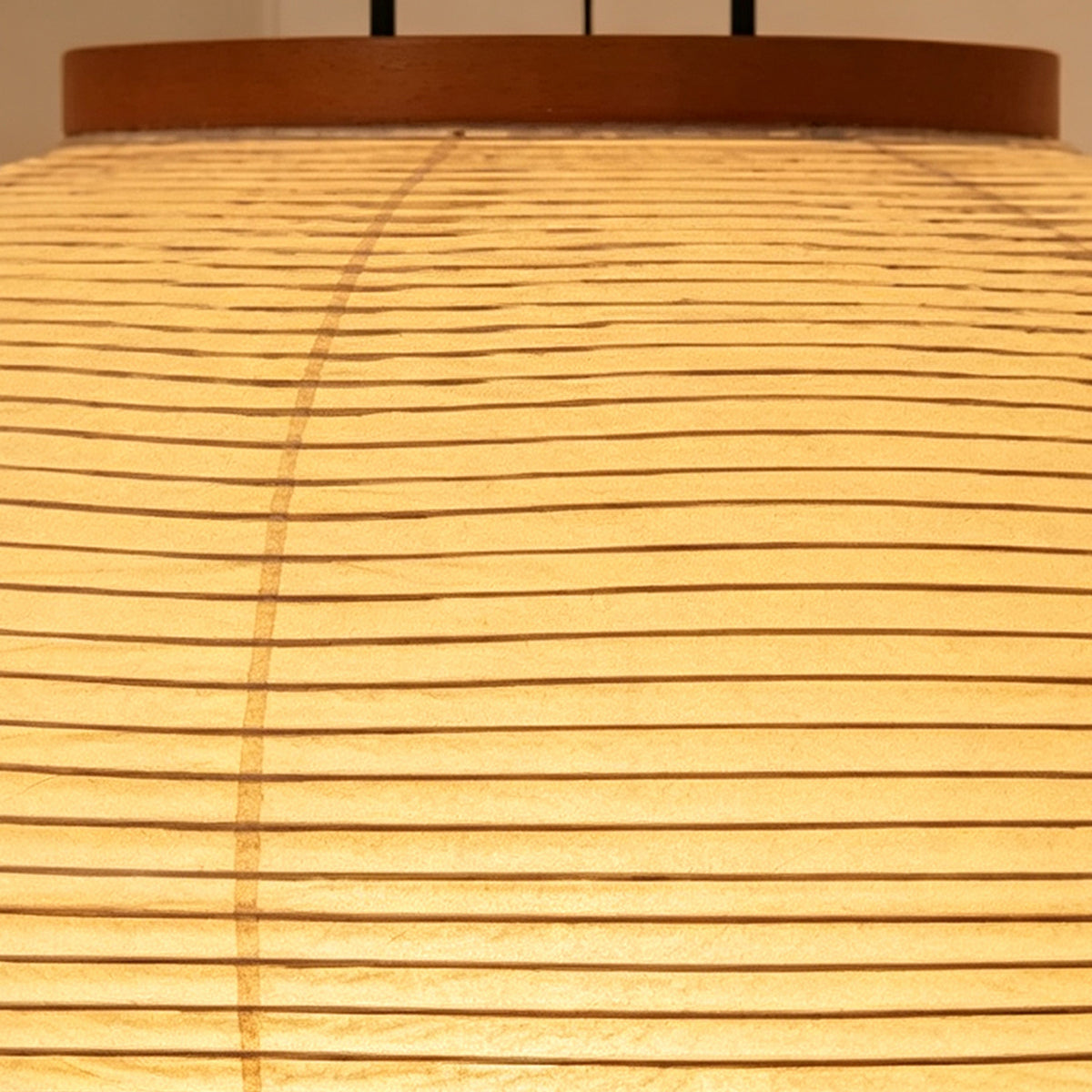 Verena Ribbed Paper Column Floor Lamp | Ribbed Paper and Metal Tripod Legs | Horizontal close-up pattern shot of the finely crafted ribbed lines on the illuminated paper shade | Severn Lighting