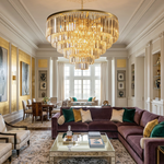 Verity Fringed Glass Tier Chandelier | Fringed Glass and Brass | Hanging in a grand living room with a purple sectional sofa and high ceiling | Severn Lighting
