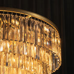 Verity Fringed Glass Tier Chandelier | Fringed Glass and Brass | Close-up view of the illuminated brass rim and fringed glass layers | Severn Lighting