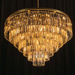 Verity Fringed Glass Tier Chandelier | Fringed Glass and Brass | Full view of the tiered chandelier glowing against a dark background | Severn Lighting