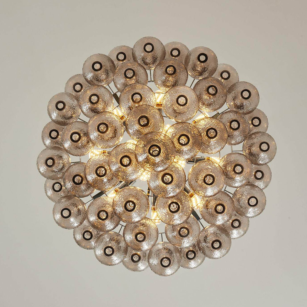 Vespera Tiered Smoked Glass Chandelier | Textured Smoked Glass | Directly underneath view displaying the glowing concentric pattern of the teardrop glass layers | Severn Lighting