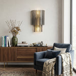 Vespera Tiered Smoky Glass Wall Lamp | Glass, Metal | Mounted as elegant accent lighting on a grey feature wall above a mid-century wooden sideboard cabinet with a blue armchair nearby | Severn Lighting