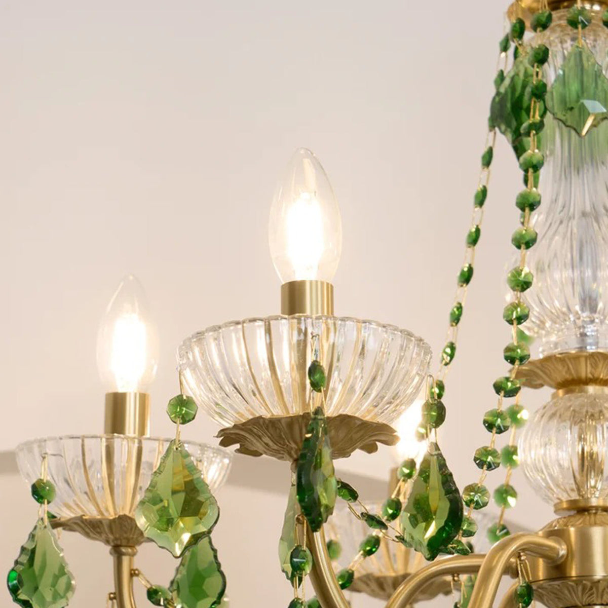 Vionne Green Crystal Drop Brass Chandelier | Green Crystal, Clear Glass and Brass | Detail shot highlighting the candle bulb and clear ribbed glass bobeche | Severn Lighting