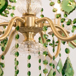 Vionne Green Crystal Drop Brass Chandelier | Green Crystal, Clear Glass and Brass | Macro detail showing the central bottom clear crystal and brass finial | Severn Lighting