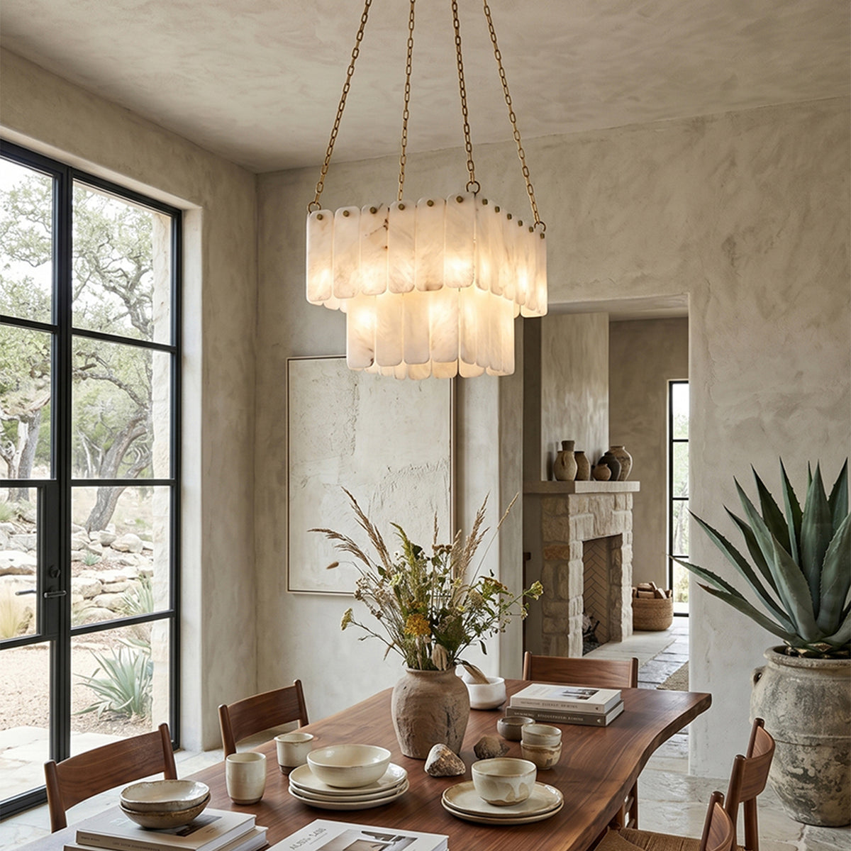 Vivienne Tiered Alabaster Chandelier | Alabaster, Brass | Hanging elegantly as a cozy dining centerpiece over a rustic wooden table with matching chairs in a bright stone-walled room | Severn Lighting