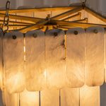Vivienne Tiered Alabaster Chandelier | Alabaster, Brass | Close-up illuminated view showcasing the warm glow and organic mineral veining patterns of the layered stone tiles | Detail shot | Severn Lighting