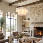 Vivienne Tiered Alabaster Chandelier | Alabaster, Brass | Positioned gracefully in a rustic luxury lounge room featuring a stone accent fireplace with a blazing fire and cozy armchairs | Severn Lighting