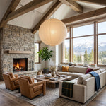 Washi Paper A Pendant Light | Japanese Wabi-Sabi Paper Lantern | Casting a warm glow in a cozy living room with a stone fireplace and large scenic windows