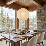 Washi Paper A Pendant Light | Japanese Wabi-Sabi Paper Lantern | Illuminating a wooden dining table setup in a bright room overlooking snowy pine trees